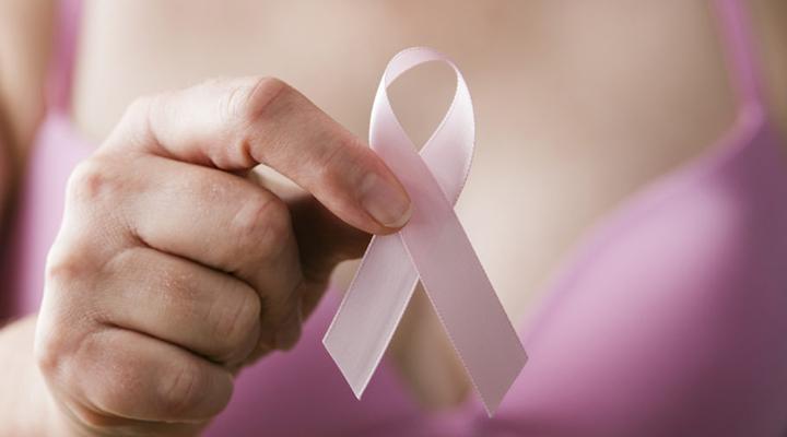 Breast cancer awareness. Woman in pink bra holding a pink ribbon, a reminder of the importance of breast examination in healthcare and medicine, to maintain and sustain a cancer-free, healthy lifestyle.